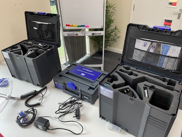 EA Technology UltraTEV tools and hard, deep carry cases with foam inserts are laid out on a white classroom table. 