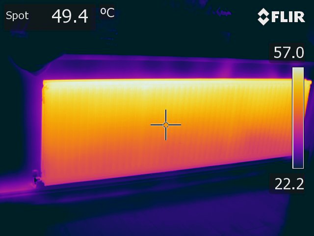 Thermal image of a radiator taken in an Ironbow palette. The top is white and yellow, indicating it is hotter, the bottom is orange and pink, indicating it is colder.