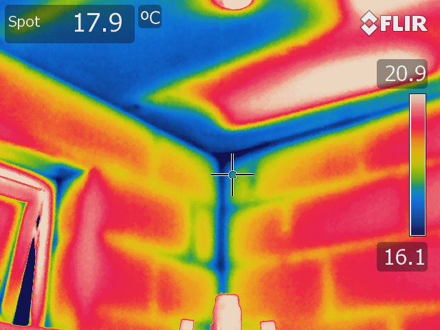 Thermal image of a wall and ceiling taken using a Rainbow colour palette. The blue spots on the ceiling indicate damp or areas susceptible to damp.