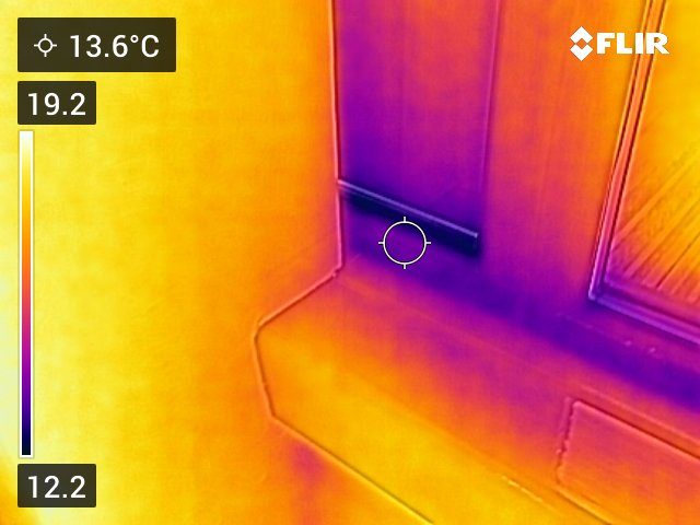 Thermal image of a window ledge indicating cold patches near the window seal. 