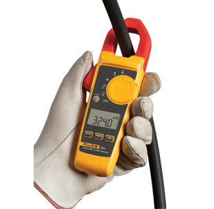 White gloved hand holding a Fluke 324 TRMS Clamp Meter. The red jaw of the clamp meter surrounds a thick, black cable.  