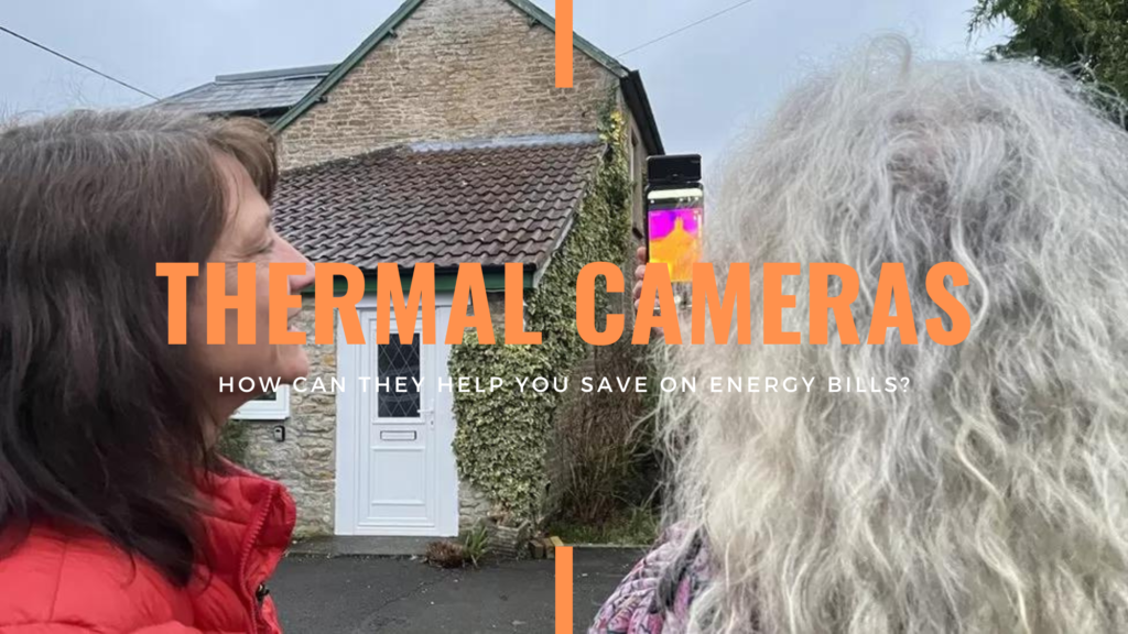 Two women are inspecting a stone home using a thermal camera attachment connected to a smartphone. Large, orange text in the centre of the image reads 'Thermal Cameras'. Underneath, smaller, white text reads 'How Can They Help You Save On Energy Bills'. 