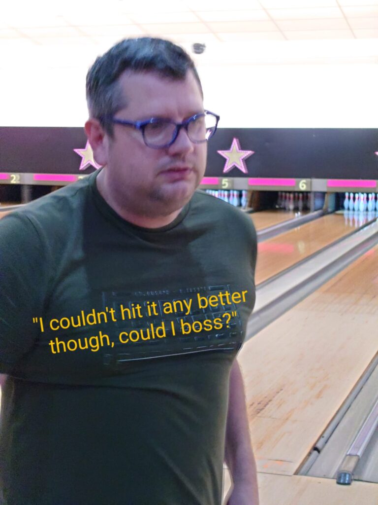 A concerned-looking Gary walks away from the bowling alley. Orange text super-imposed over his t-shirt reads "I couldn't hit it any better though, could I boss?"