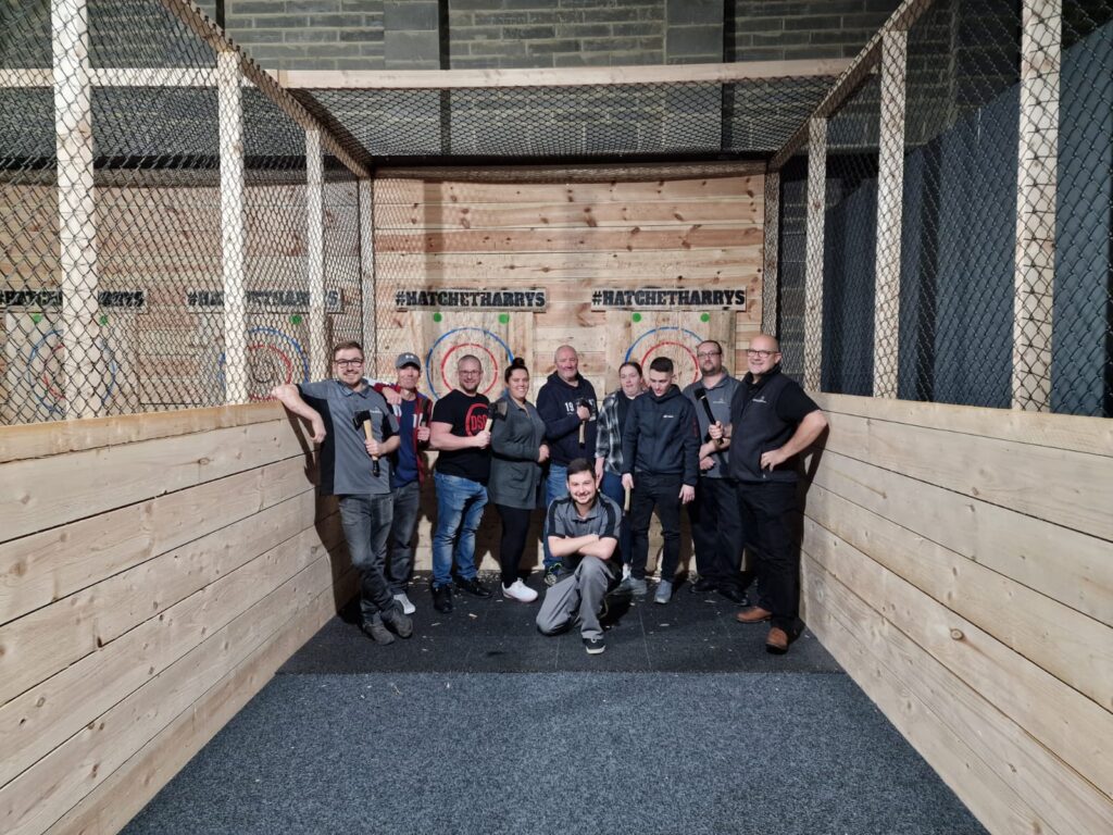 The Dispatch team pose for a group photo in front of the wooden targets. 