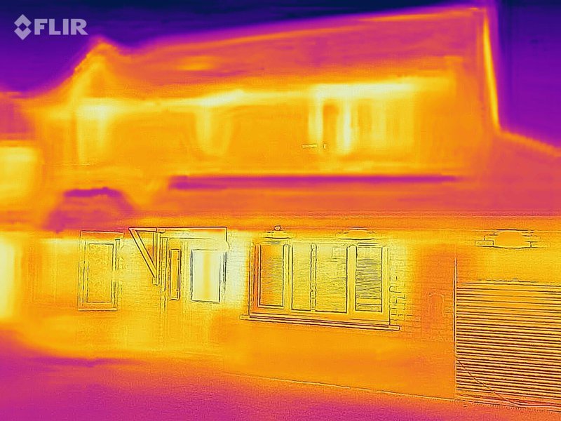 Thermal image of an energy inefficient home. The house is bright yellow. 