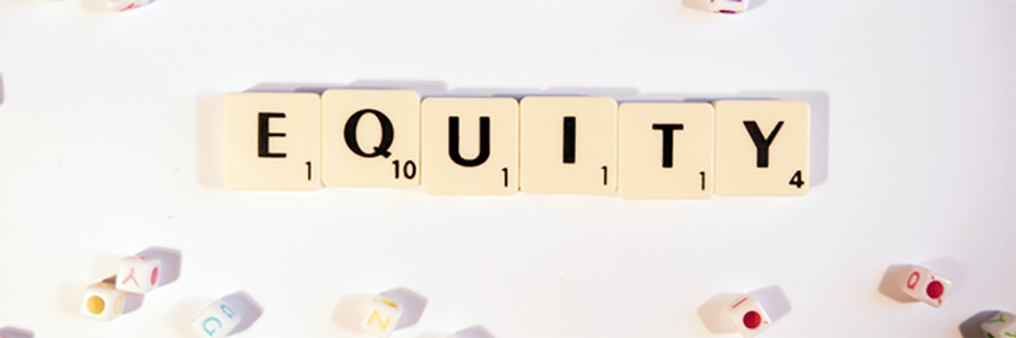 The word "Equity" is spelt out using Scrabble tiles. Small beads with letters in various colours lie scattered around the word. The background is an off-white colour. 