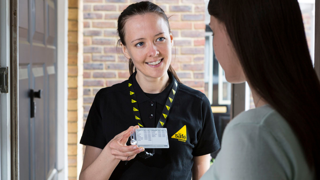 A Gas Safe registered engineer shows her Gas Safe ID badge to the female homeowner/tenant. 