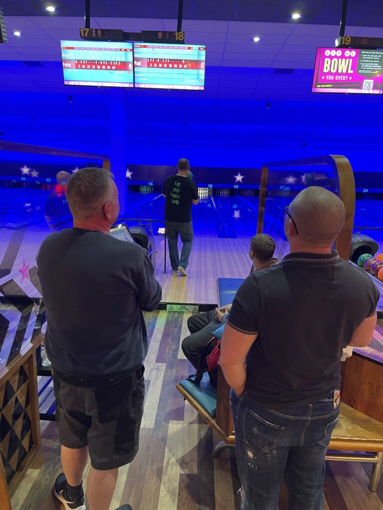 Members of the Dispatch team watch as another member of their team goes to bowl. 