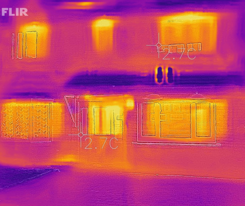 Thermal image of an energy efficient home. The house is purple and blue with the only instances of yellow spots coming from the windows.