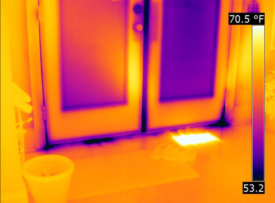 Thermal image of a window. Around the window there are dark blue cold spots indicating cold air leaks. 