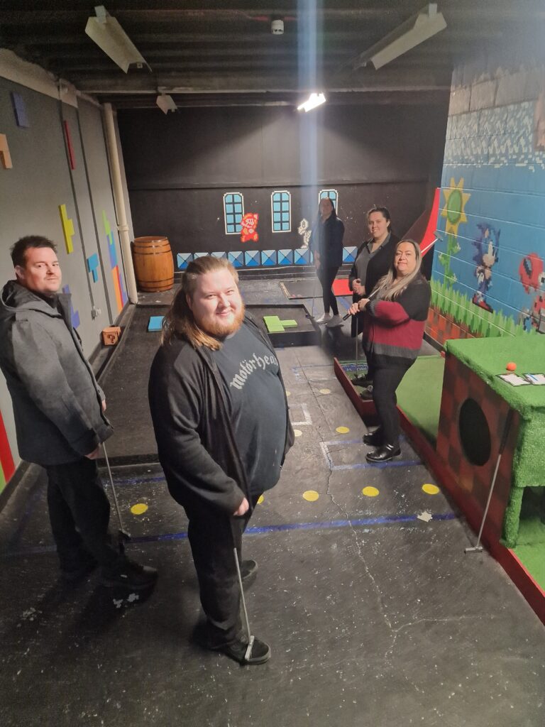 The Cal Admin team stand around a Mario-inspired mini/crazy golf hole. From left to right: Michael, Adam, Clare, Collette, and Caitlin. 