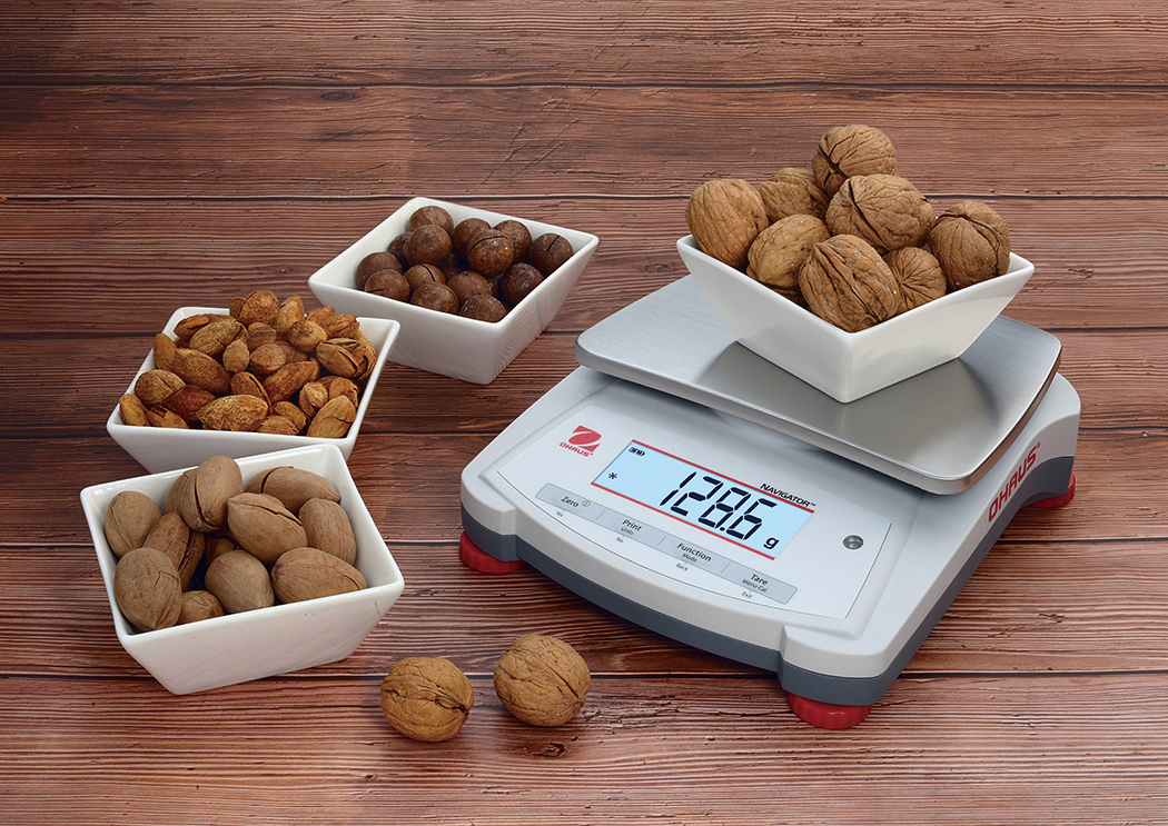 Ohaus Navigator NV Precision Portable Balance weighing some nuts.