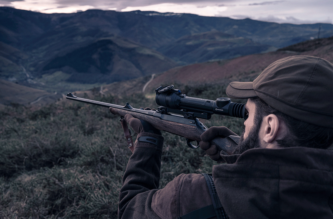 Pulsar Talion XQ35 Pro Riflescope being used by a hunter looking over a hillside.
